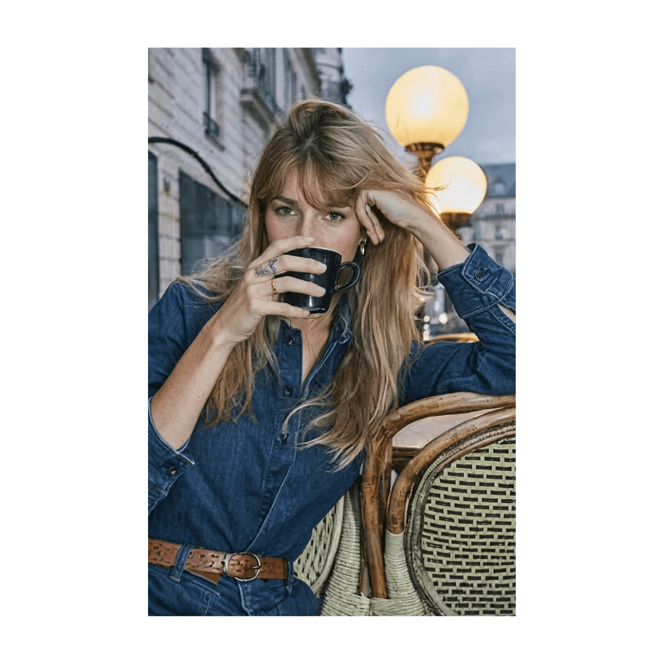 Woman in a denim shirt seated at a Paris cafe